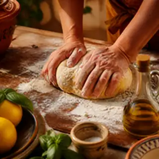 Des mains qui pétrissent une pâte, citrons et basilic autour